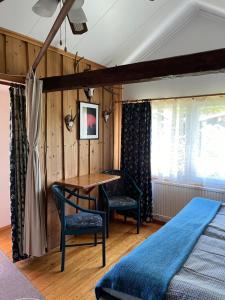 BredsatraDrei Jahreszeiten的一间卧室配有桌子、两把椅子和一张床