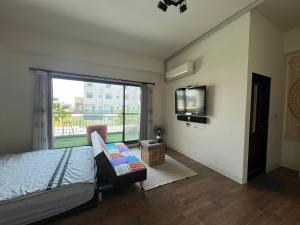 台南回家旅行的一间卧室配有一张床和一台平面电视