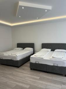 萨拉热窝Davud Apartments的白色墙壁客房的两张床