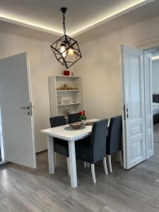 萨拉热窝Davud Apartments的一间配备有白色桌椅的用餐室