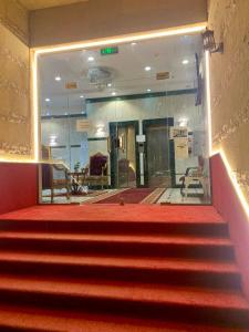 麦加Najmat Alnoor Almaabdah Hotel的红色的楼梯,位于一栋铺有红地毯的建筑中