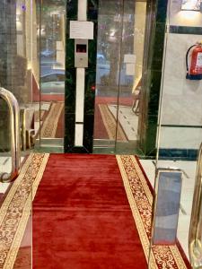 麦加Najmat Alnoor Almaabdah Hotel的玻璃门前的红地毯