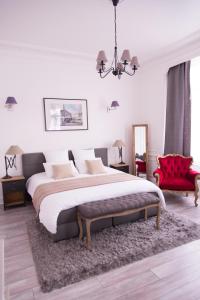图尔昆Chic Appart - Sauna privatif的一间卧室配有一张大床和一张红色椅子