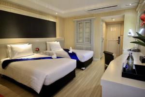 坤敬โรงแรมวีวิช V Wish Hotel的酒店客房配有两张床和一张书桌