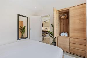 卢森堡Clausen Hideaway Modern Accommodation的卧室配有白色的床和镜子