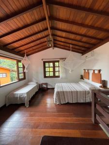 莫罗圣保罗Vila Sofia chalès的一间卧室设有两张床和木制天花板