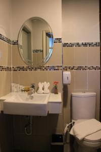 坤敬โรงแรมวีวิช V Wish Hotel的一间带水槽、卫生间和镜子的浴室