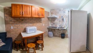 伦索伊斯Pousada Nativos Lençois的厨房配有冰箱和带微波炉的桌子。