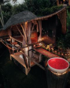 SelatCamaya Bali - Magical Bamboo Houses的前面有一个红色碗的小小屋