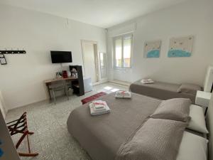 阿尔盖罗Rossocorallo Rooms的一间带两张床和电视的客厅
