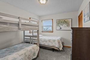 Salvo7214 - Bakin in the Sun by Resort Realty的一间卧室设有两张双层床和一扇窗户。
