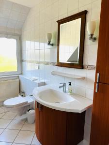 诺德施泰特Doppelhaushälfte nahe Flughafen Hamburg的一间带水槽、卫生间和镜子的浴室