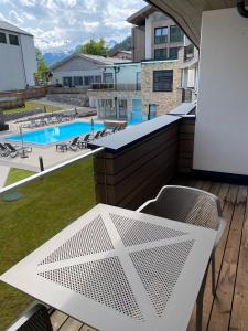 滨湖采尔Spa Apartments - Zell am See的一个带桌椅的阳台和一个游泳池