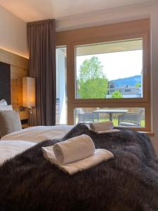 滨湖采尔Spa Apartments - Zell am See的一间卧室设有一张大床和大窗户