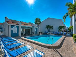 圣徒皮特海滩Madeira Beach Yacht Club 343h的一座带蓝色躺椅的游泳池,位于大楼旁