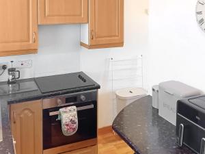 斯托诺韦Hynish House的厨房配有炉灶和烤箱上的毛巾