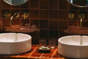 比索达雷加Torel Quinta da Vacaria - Douro Valley的浴室设有2个水槽和2个玻璃杯,位于台面上