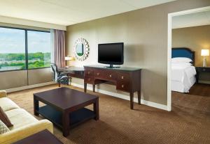 莱尔莱尔内珀维尔喜来登酒店的酒店客房配有一张床和一张书桌及一台电视