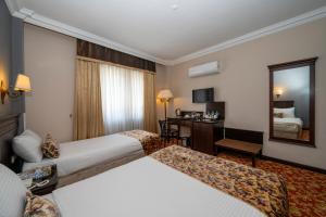 伊斯坦布尔Pera Rose Hotel - Taksim Pera的酒店客房,设有两张床和镜子
