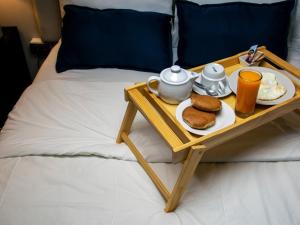 齐克拉约Hotel America Chiclayo的床上的食品托盘,含早餐