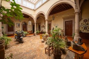 杜兰戈Hotel Posada San Agustin的一间大房间,里面装有植物和摩托车