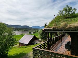 TornesTraditional Norwegian log cabin with sauna by the sea的一座带草屋顶的建筑,设有木甲板