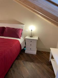 RoccaveranoAlbergo del Bramante的一间卧室配有红色的床和床头柜