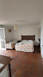 安东尼娜Hotel Camboa Antonina - PR的一间带两张床的卧室,铺有瓷砖地板