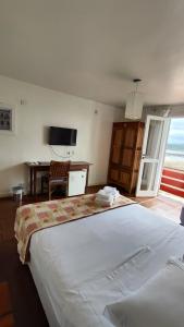 安东尼娜Hotel Camboa Antonina - PR的卧室配有一张白色大床和一张书桌