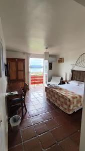 安东尼娜Hotel Camboa Antonina - PR的一间卧室配有一张床、一张书桌和一个窗户。
