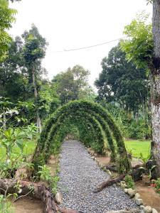 武吉拉旺Wisma Batu Mandi and offers jungle tours的花园中带有碎石路的拱门