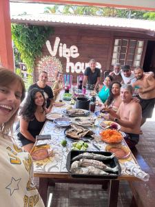 弗洛里亚诺波利斯Vibe House Hostel的一群人坐在桌子旁吃着食物