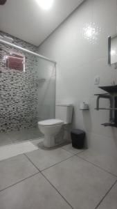 伦索伊斯Pousada Vista da Serra - Suzart的一间带卫生间和玻璃淋浴间的浴室