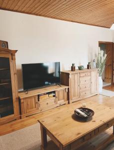 格拉茨Uriges Bauernhaus mit Blick auf Graz的客厅配有电视和木桌