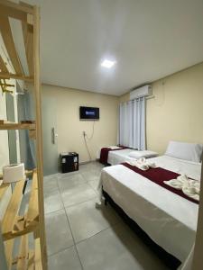 伦索伊斯Pousada Vista da Serra - Suzart的一间酒店客房,设有两张床和电视