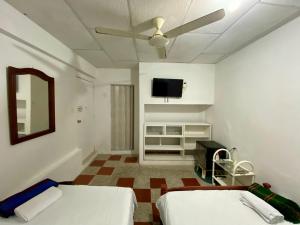 卡塔赫纳Habitación Multiple cerca de aeropuerto的客房设有两张床和一台平面电视。