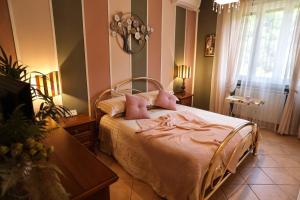 莱里奇L'Oasi tra mare e monti的一间卧室配有一张带粉色床单和一张桌子的床。