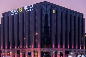 利雅德Novo Hotel的一座大建筑的侧面有标志