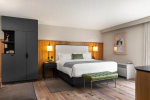 诺沃克The Watershed - Formerly Hotel Zero Degrees的一间卧室设有一张大床和一个绿色凳子
