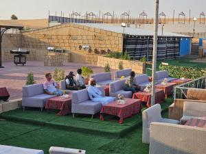 HunaywahDesert Safari Dubai Over Night Stay的坐在沙发和桌子上的一群人
