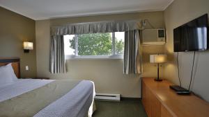 纳奈莫外交汽车旅馆的酒店客房,配有床和电视