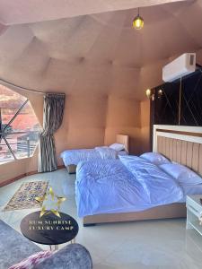 瓦迪拉姆RUM SUNRlSE LUXURY CAMP的一间卧室设有蓝色的床和窗户。
