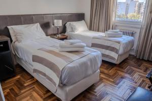 马德普拉塔泛美大酒店的两张位于酒店客房的床 - 带毛巾