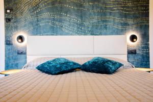莱万托Bellevue - Rooms & Suites的一间卧室配有一张大床和两个蓝色枕头