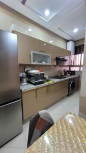 梅克内斯Bel appartement dans une résidence calme的厨房配有不锈钢冰箱和桌子