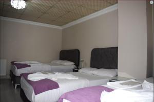 伊斯坦布尔坤贝特酒店的酒店客房,配有三张床和毛巾