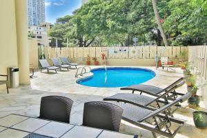檀香山威基基阿瓜阿洛哈冲浪酒店的一个带椅子的庭院和一个小型游泳池