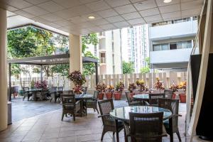 檀香山威基基阿瓜阿洛哈冲浪酒店的一座配有桌椅的户外庭院和一座建筑