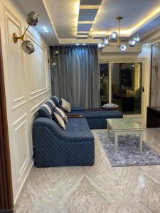 亚历山大Join Inn Apartments的客厅配有蓝色的沙发和桌子