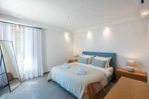 利昂尼迪翁Sampatiki Suites - 4 Star Seaview Luxury Suites With Breakfast And Spa - Opened 2024的一间卧室配有一张床、一张桌子和一个窗户。